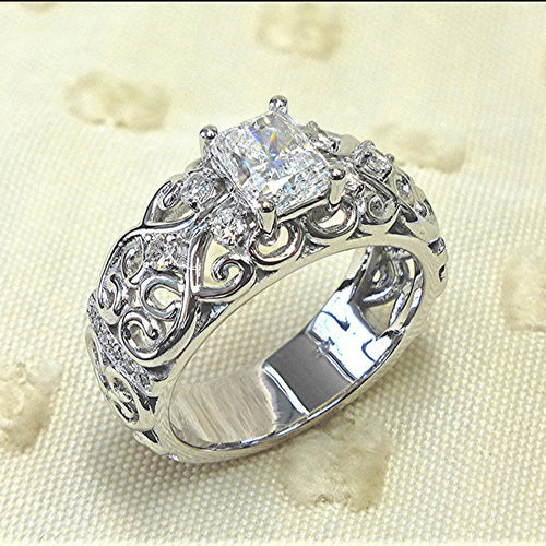 White gold filigree clear rectangle CZ ring on cream fabric
