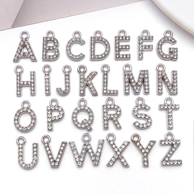 Metallic alphabet letter charms arranged on a light background