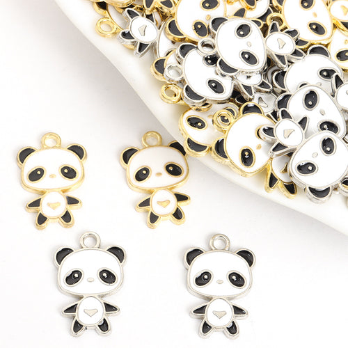 Assorted black and white enamel panda charms arranged beside a tray on white