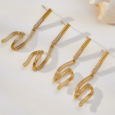 On-ear view of long crystal wave drop earrings in main image 1.