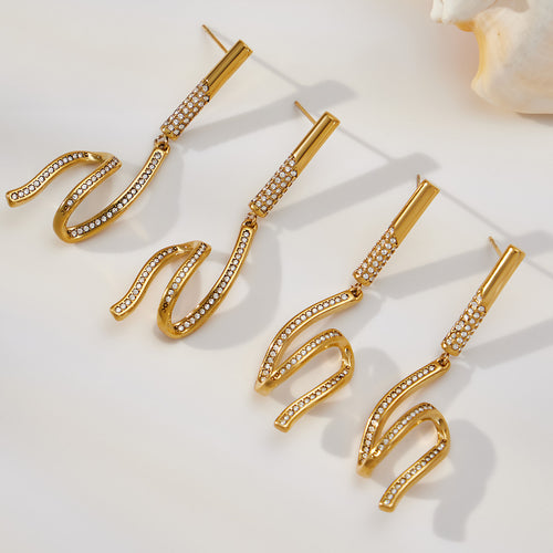 On-ear view of long crystal wave drop earrings in main image 1.