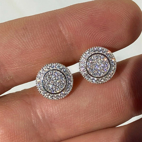 White gold round halo pavé crystal studs held on fingers