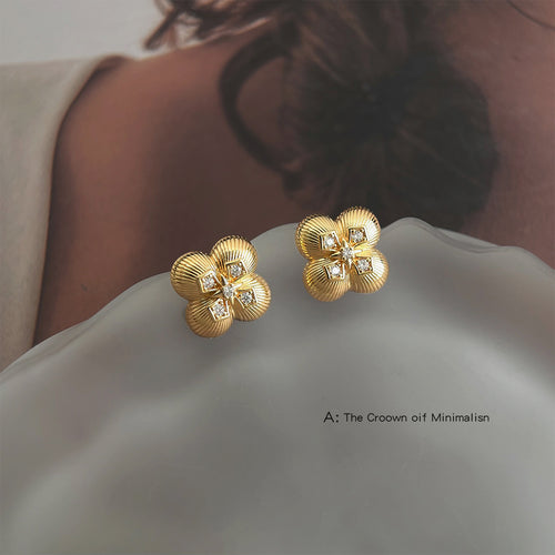 Gold ribbed clover crystal studs on frosted glass surface