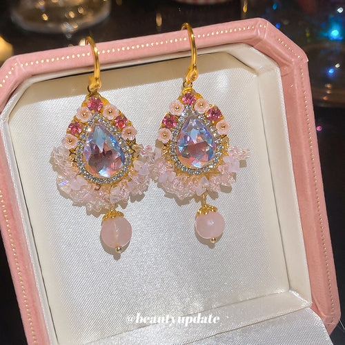 Layered pink and clear crystals around faceted centers and pearl-like drops displayed in a close product arrangement.