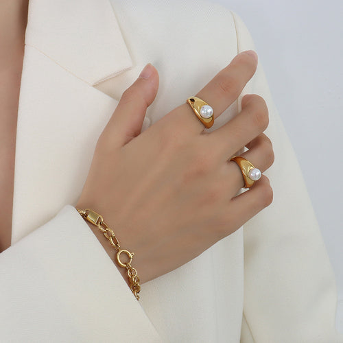Two gold dome side pearl rings worn on hand with gold chain bracelet