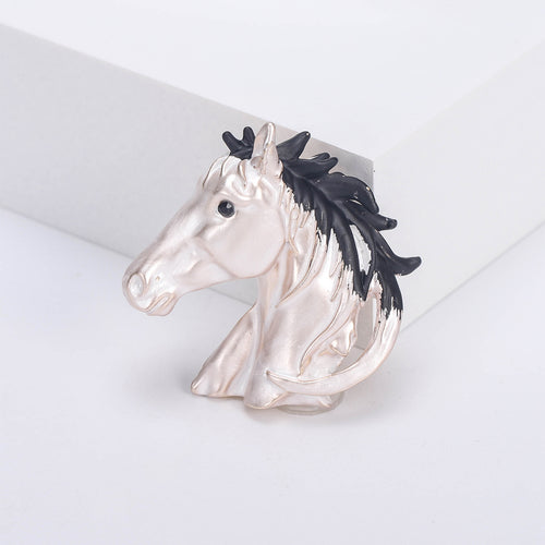 Angled display of the horse head brooch on a white surface