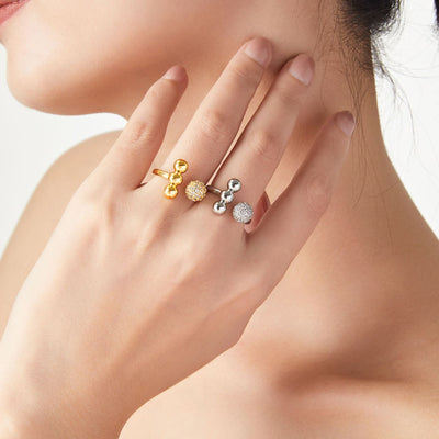Model hand wearing gold and steel open ball pave rings