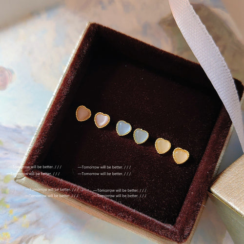 Gold-tone pearlescent heart stud earrings shown as all three colors.