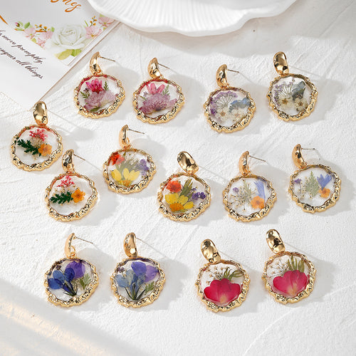Assorted gold wavy-frame resin dried flower stud earrings in many floral colors