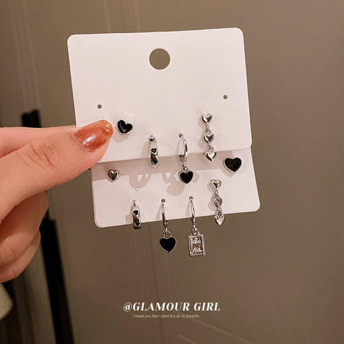 two unrelated multipiece earring sets with heart and starburst motifs shown in the first close product view