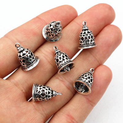 Bell-shaped charm with open filigree floral detail in a group view on a white background