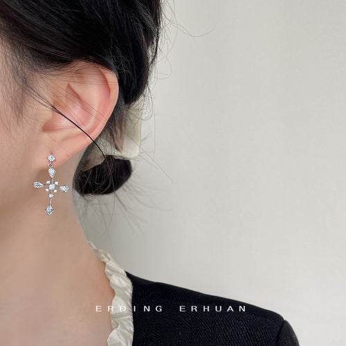 Model wearing silver crystal cross drop stud earring
