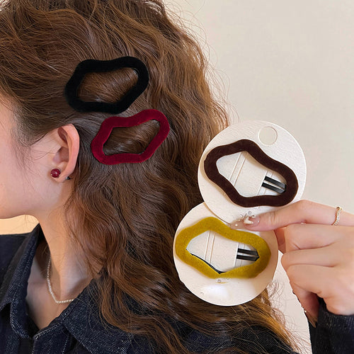 Black and burgundy velvet clips worn in wavy hair with brown and mustard on cards