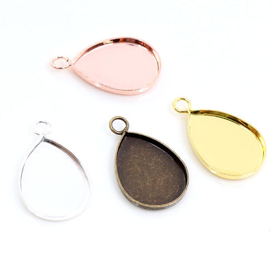 Image 1 showing teardrop pendant bezel settings in four plated finishes in the pictured colors and forms