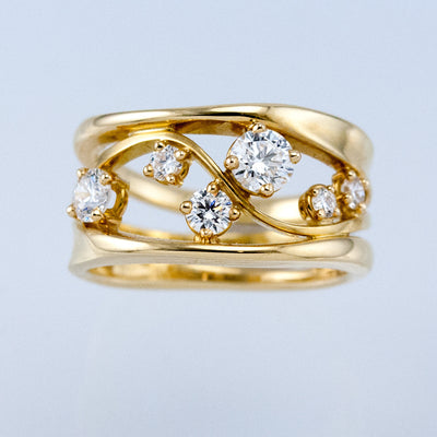 Front view of gold tone layered wave ring with scattered clear crystals