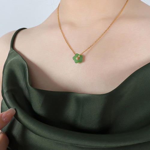 Deep green star stone pendant necklace worn on model