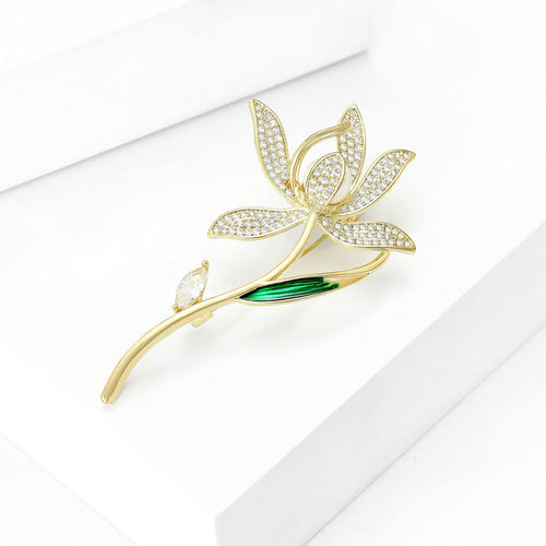 Gold zircon magnolia brooch angled on white display blocks