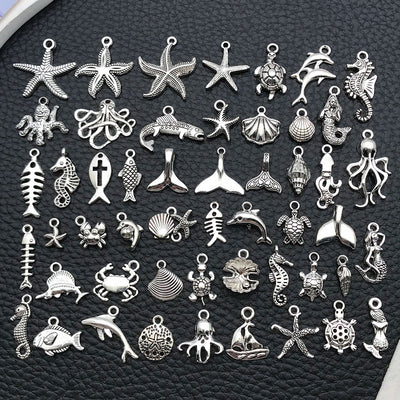 Antique silver starfish and seahorse charms arranged on a light background