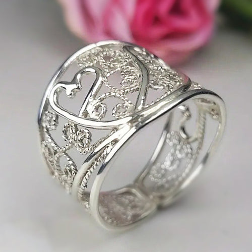 Second product view showing silver-tone filigree heart openwork extra-wide ring