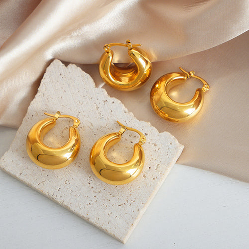 Two pairs of gold chunky crescent hoops on stone and silk