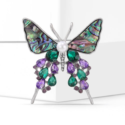 Angled close-up showing crystals on the shell butterfly dangle brooch