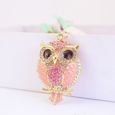 Pink owl charm with pale pink panels and pink rhinestones on a gold-tone frame.