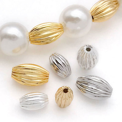 Gold-tone spacer bead beads arranged on a light background