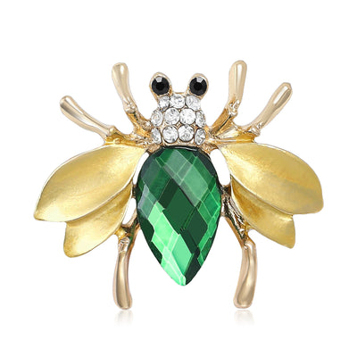 Gold bee brooch with green faceted body front view on white