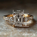 Emerald-Cut Clear Solitaire Ring With Round Side Stones In Gold Tone view 4