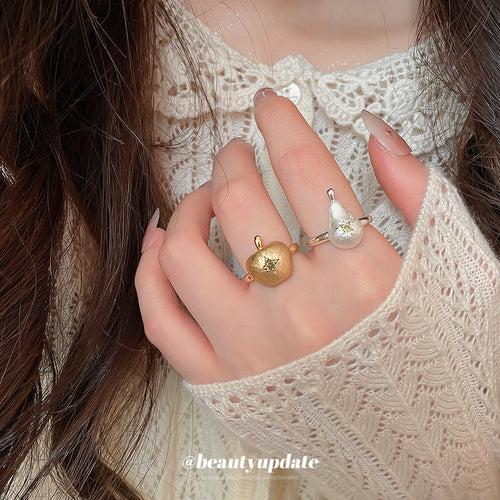 Gold apple and silver pear open rings worn on two fingers
