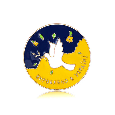 Front view of symbolic blue and yellow peace dove enamel round brooch