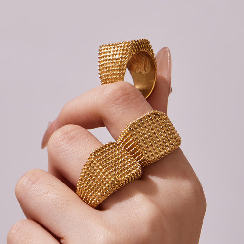 Side and top view of gold beaded square signet rings on fingers