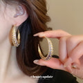 Gold Tone Crescent Hoop Earrings with Purple Crystals view 1