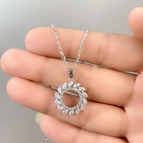 Side view of silver tone olive leaf circle pendant necklace