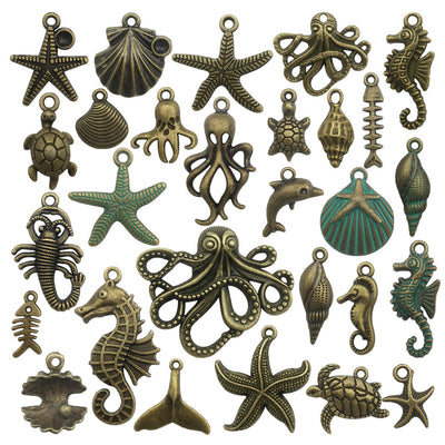 Gold-tone turtle and shell charms arranged on a light background