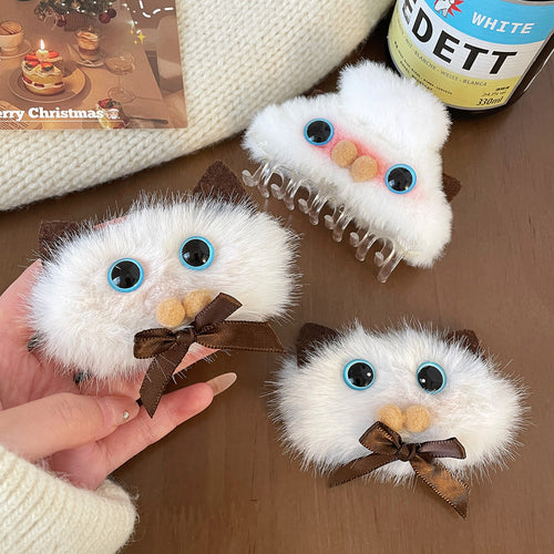 Three fluffy white cat hair clips on table including bow and claw styles