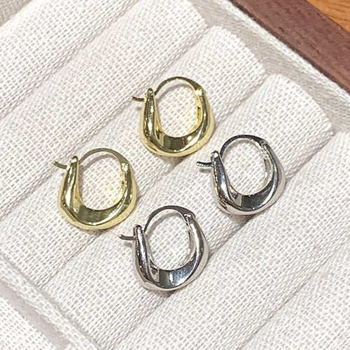 smooth chunky u shape huggie hoop earrings in two tones shown in an on-ear styling view
