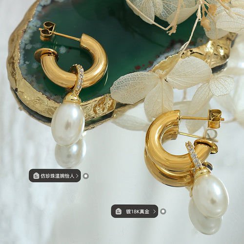 Display view of gold tone crystal hoop earrings with white drop in main image 2.