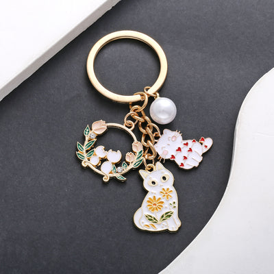Front product photo of white cat heart flower wreath and pearl enamel keychain showing the pictured design arrangement