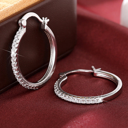 Silver hoop pair showing hinge clasps on red cloth display
