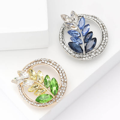 Front view of the circular crystal leaf sprig brooch in green and blue brooch and its color options