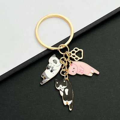 Front product photo of pink tortoiseshell and black cat enamel paw print charm keychain showing the pictured design arra