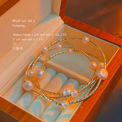 Gold twisted triple pearl bracelet coiled in wooden box
