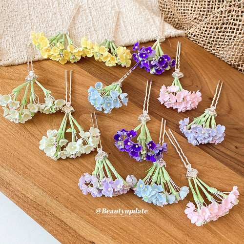 Assorted pastel flower U-pin hair accessories laid on wood table