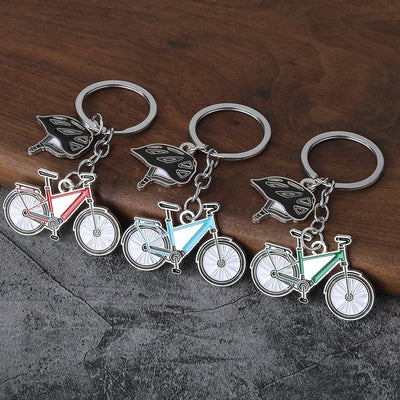 Three bicycle-and-helmet keychains in different frame colors