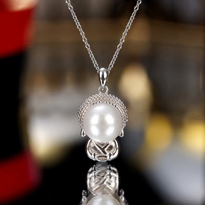 Silver faux pearl Buddha pendant necklace hanging with reflection