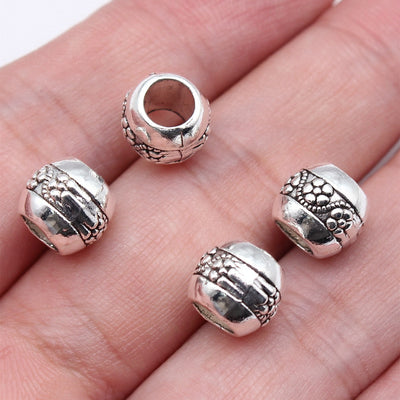 Ornate Barrel Large Hole Bead in Antique Silver Finish shown in image 1, highlighting raised floral bands and a rounded 