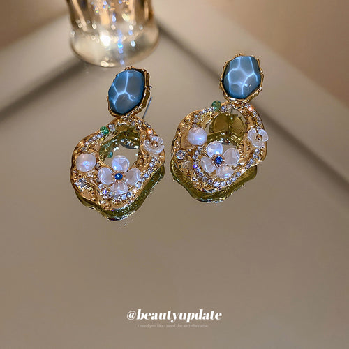 Gold Openwork Pearl Crystal Drop Earrings Polished Metal Jewelry modeled at the ear