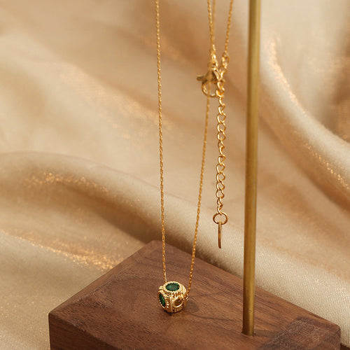 Gold green stone cube pendant on stand showing clasp and extender
