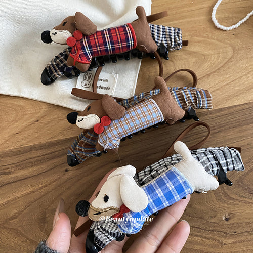 Three plaid fabric dachshund claw clips on wood table